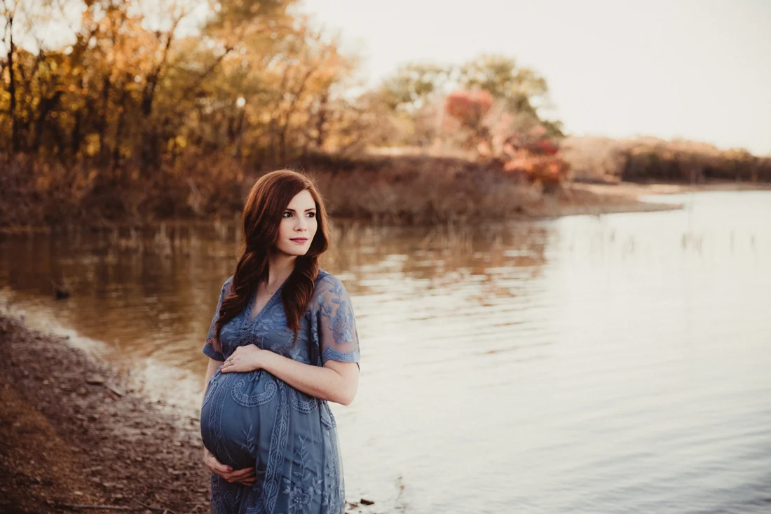 An expectant mother beside a lake, photographed by Twig & Olive