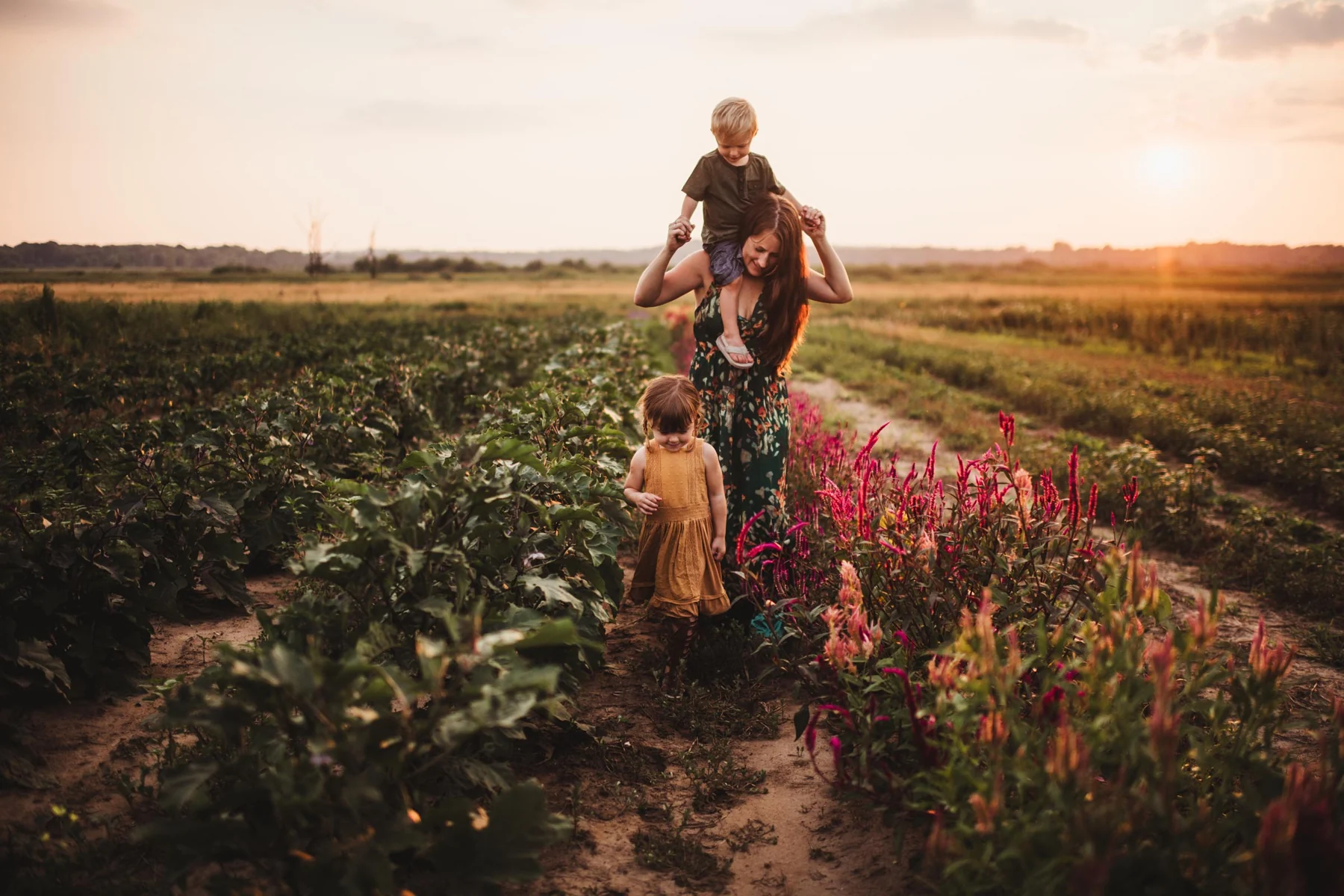 A mother and two children together in a flower field