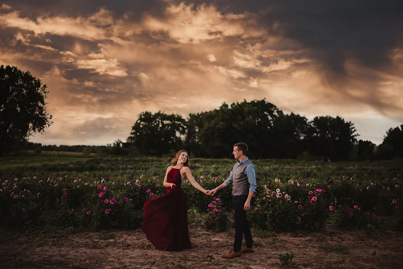 A couple in a flower field beneath a dramatic sky, from the Cloud Overlay Volume I examples.