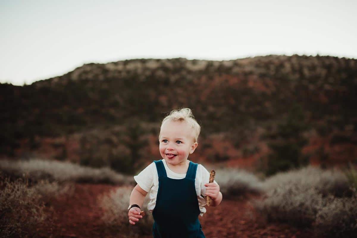 Little Boy in Blue Overalls in Desert
