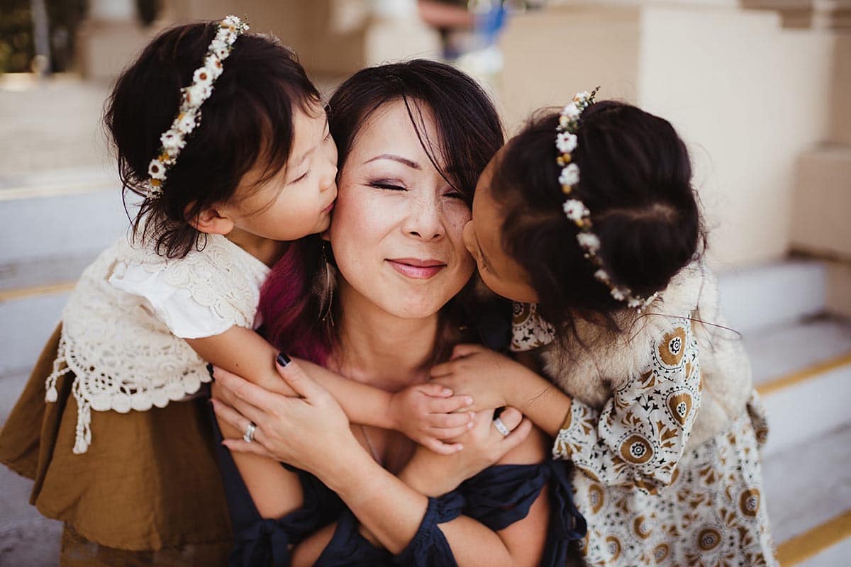 Little Girls Kissing Mom on Cheeks