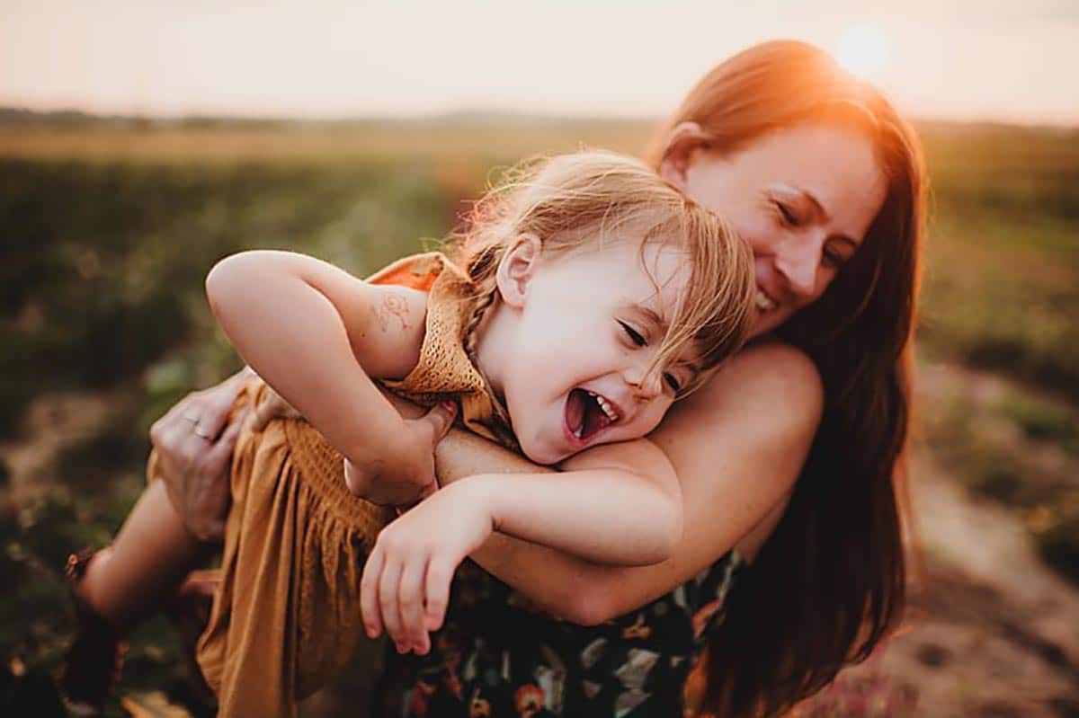 Mom Holding Laughing Daughter