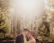 A romantic wedding photography moment captured during the Wedding Photography Online Workshop, featuring a couple embracing in a serene forest with natural sunlight filtering through.