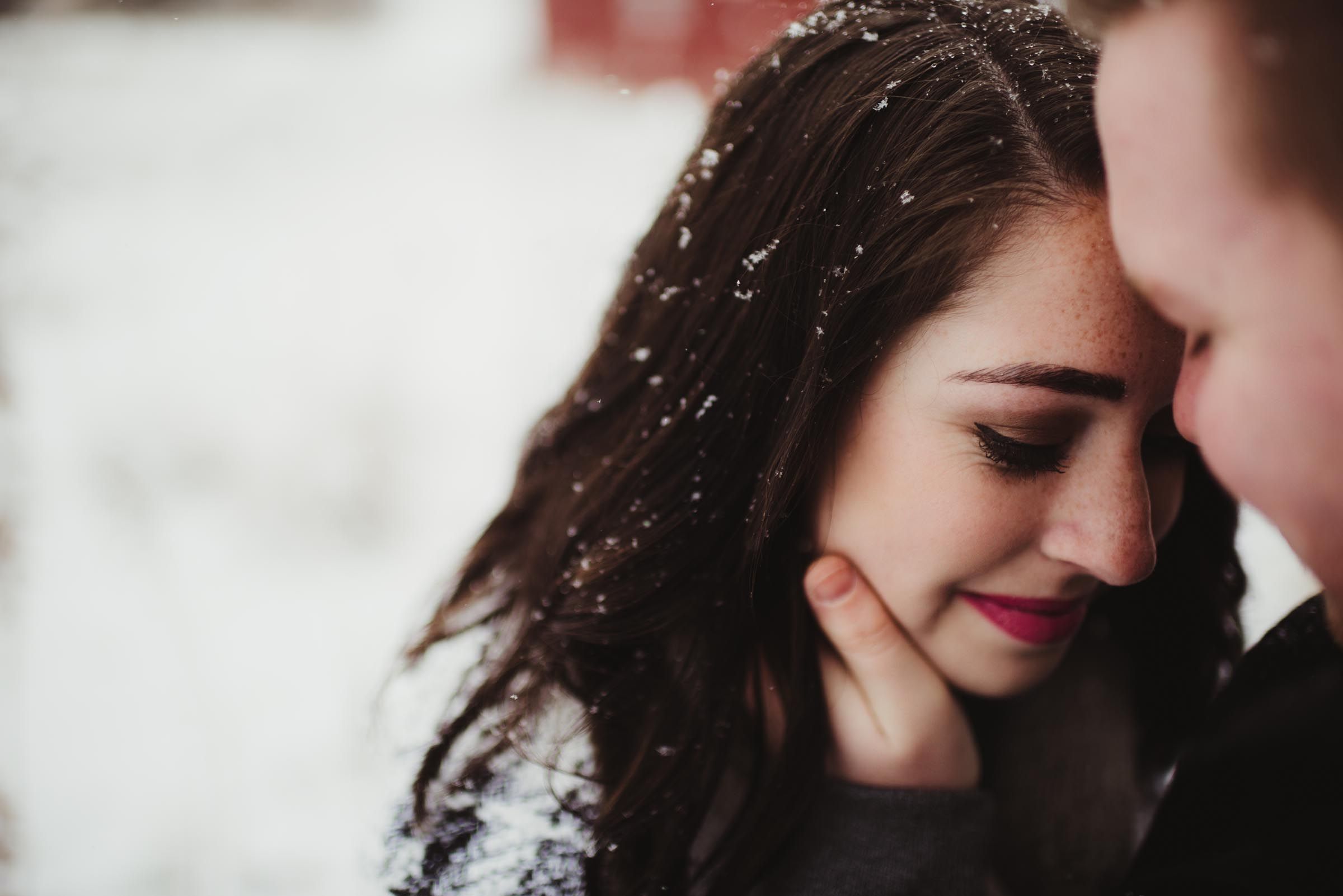 man caressing woman's face in snow