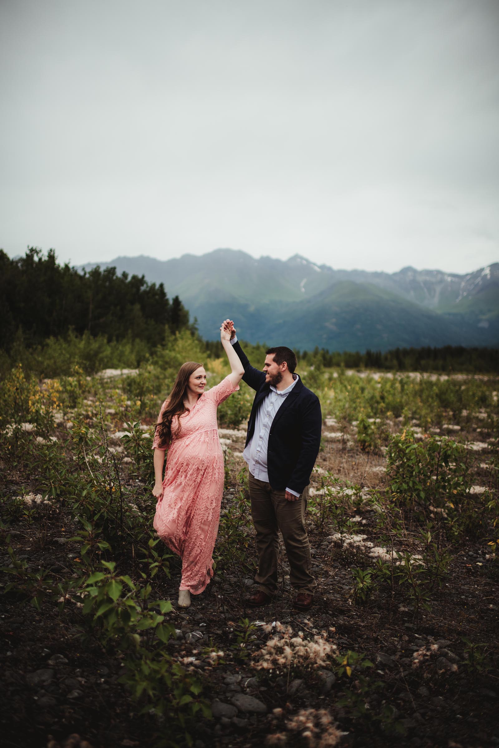 man twirling woman in an Alaskan foothill