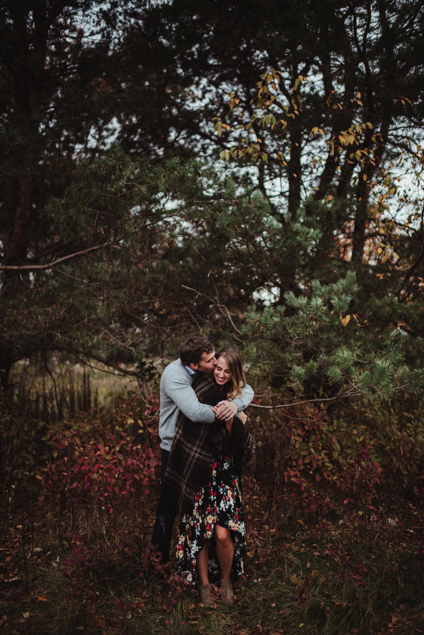 man hugging woman from behind in autumn