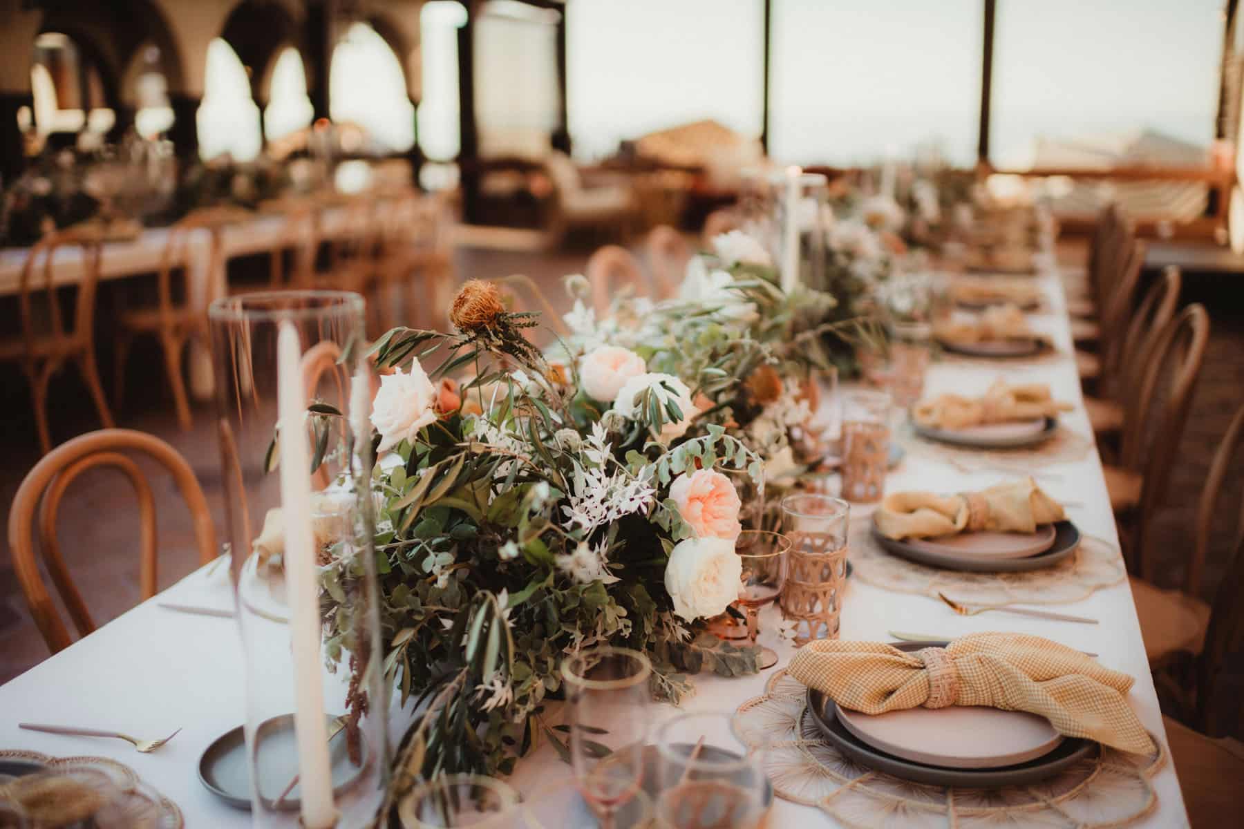 Elegantly arranged wedding table with floral centerpieces and vintage glassware in a romantic venue.