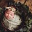 baby swaddled in bucket with floral tie back