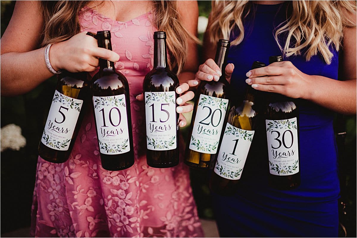 Ladies Holding Anniversary Wine Bottles