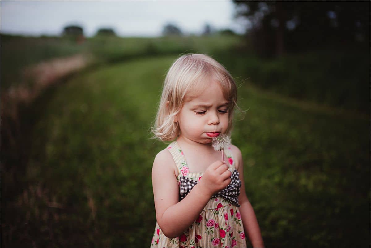 Little Girl Blowing on a Dandelion