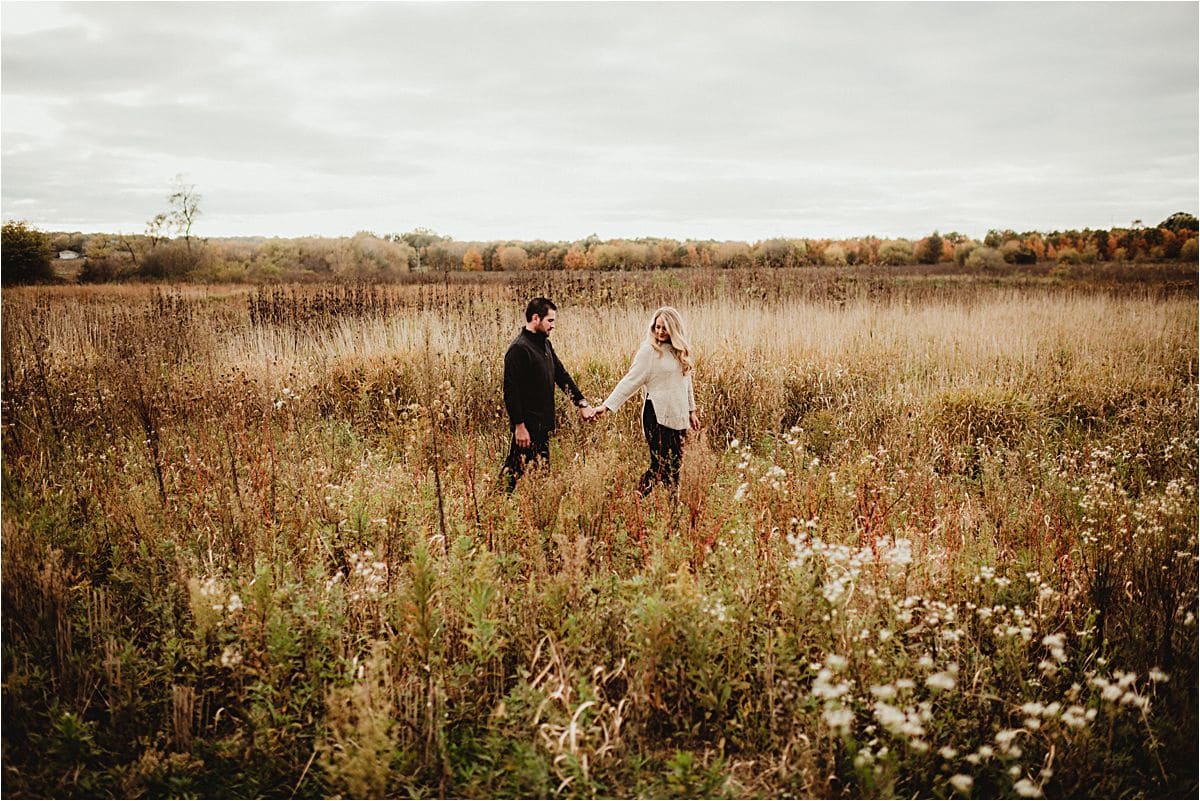 Hazy Skies Engagement Session Woman Leading Man in Field