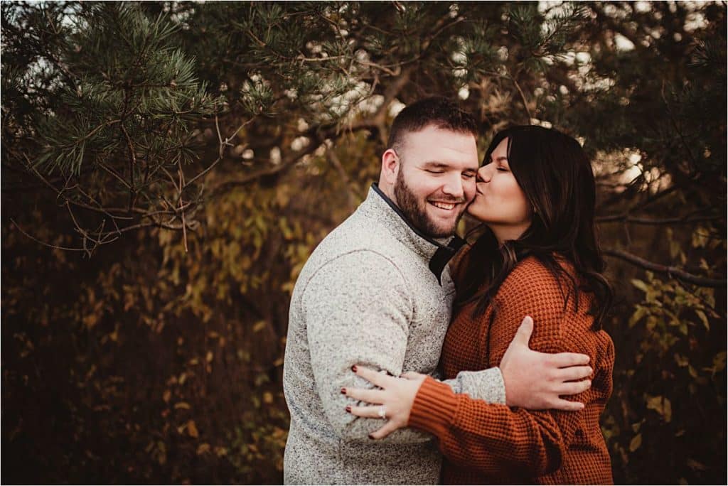 Late Fall Engagement Session Woman Kissing Man on Cheek