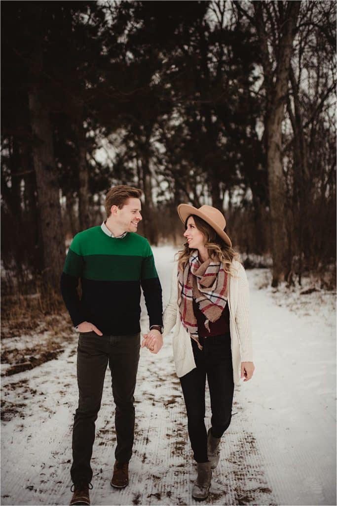 Snowy Woods Engagement Session Couple Holding Hands Walking