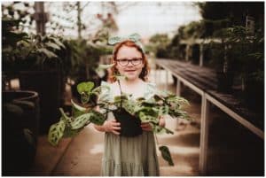 Little Girl Holding Plant