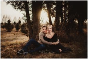 Tree Farm Engagement Session Couple Snuggling by Tree