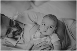 In Home Newborn Session Dad Snuggling Baby