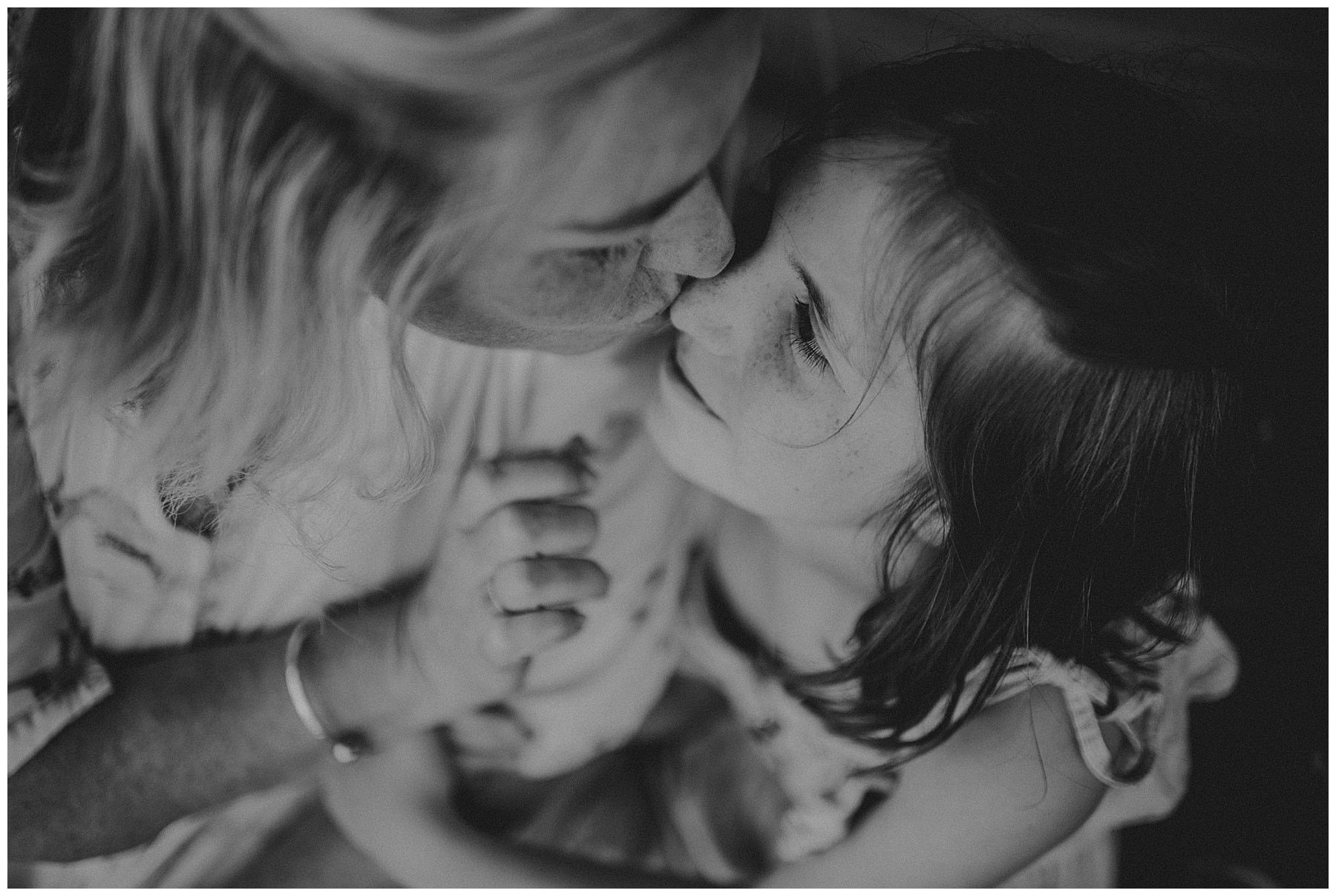 Black-and-white close-up of a mother kissing her daughter during their Sydney portrait session.