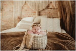 Newborn in Basket on Bed