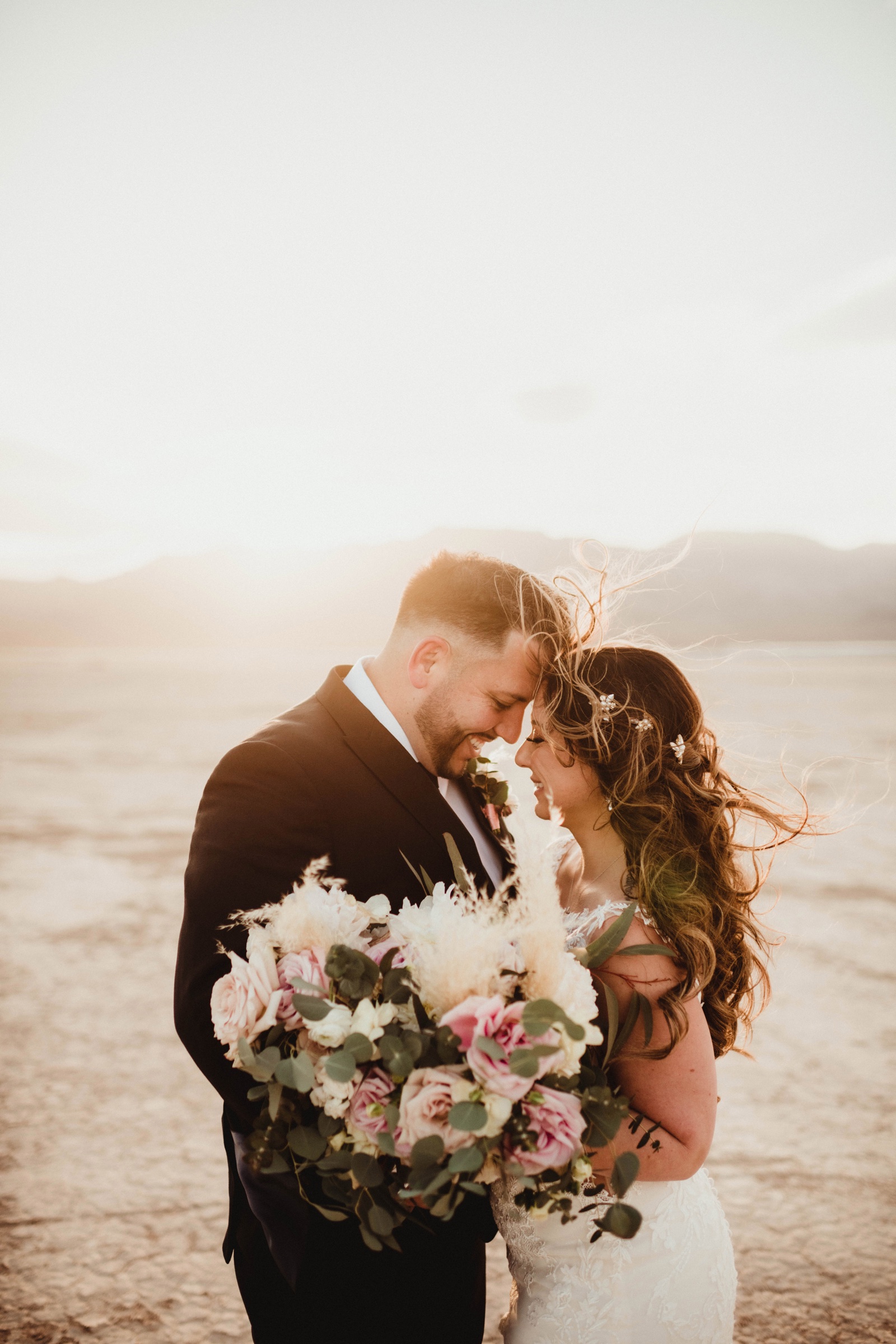 Bride and groom with wedding bouquet at a dry lake location