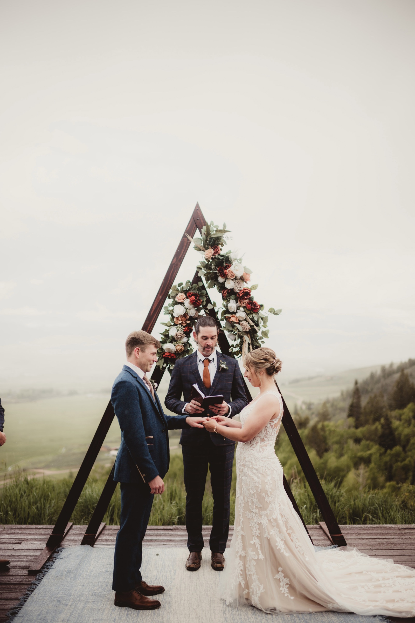 Outdoor wedding ceremony under a floral arch photographed by Twig and Olive Photography