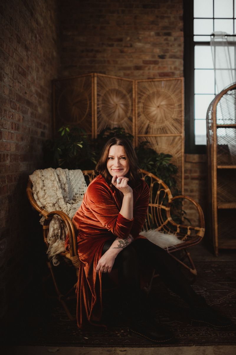Branding portrait of a woman seated in a rattan chair