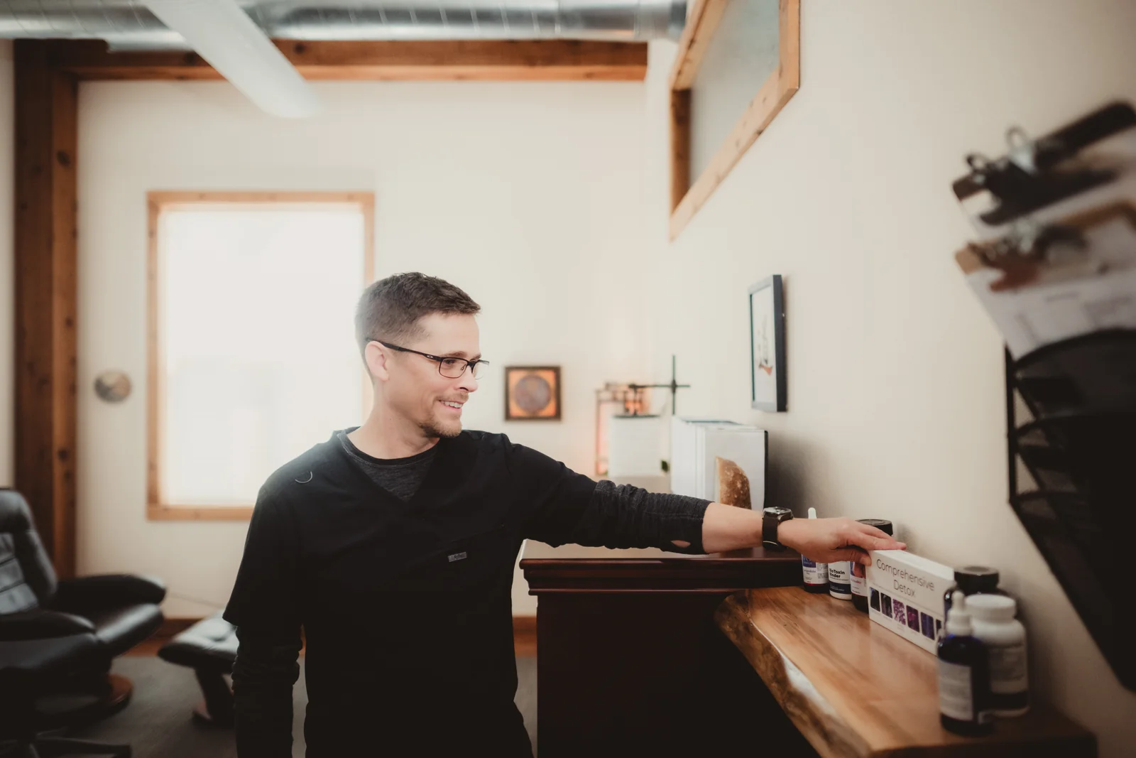 A man reaches for a product on a shelf in the workspace.