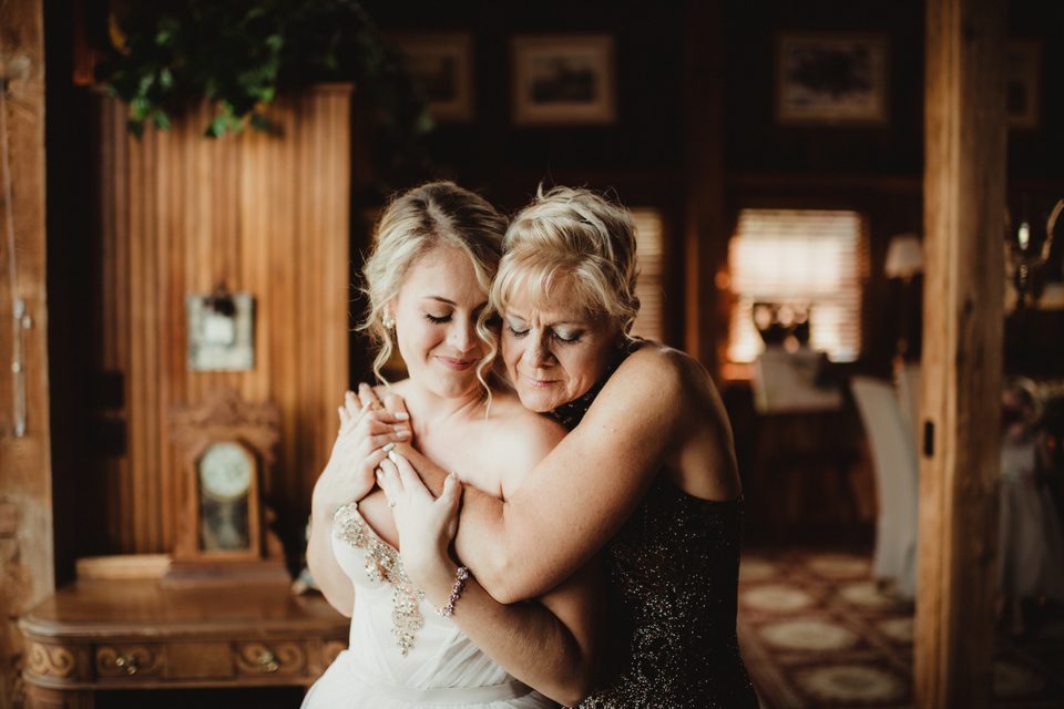 Two women embracing during wedding preparations.