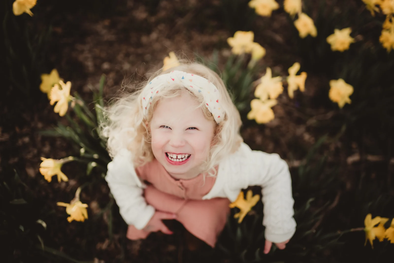 Child laughing among yellow flowers A child laughing among yellow flowers, photographed from above.