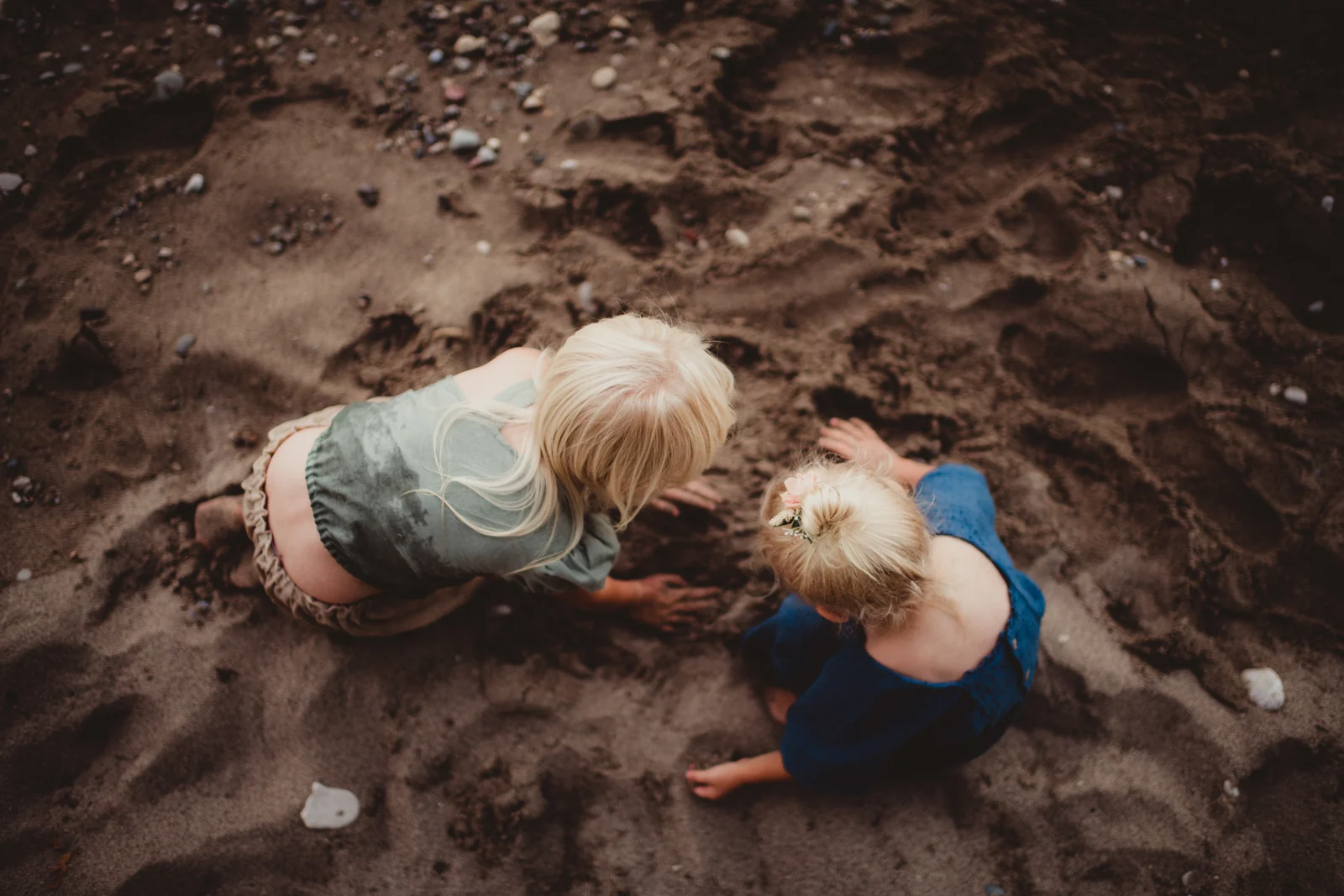Children on the sand from above Two children playing on dark sand, photographed from above.