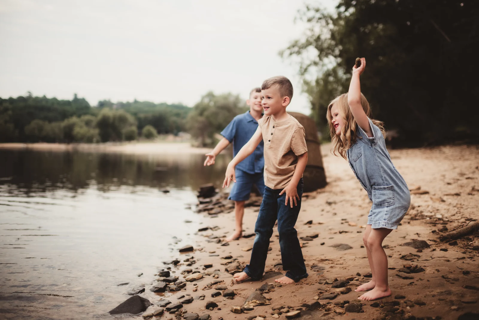 Children playing by the water Three children playing together at the sandy edge of the water.