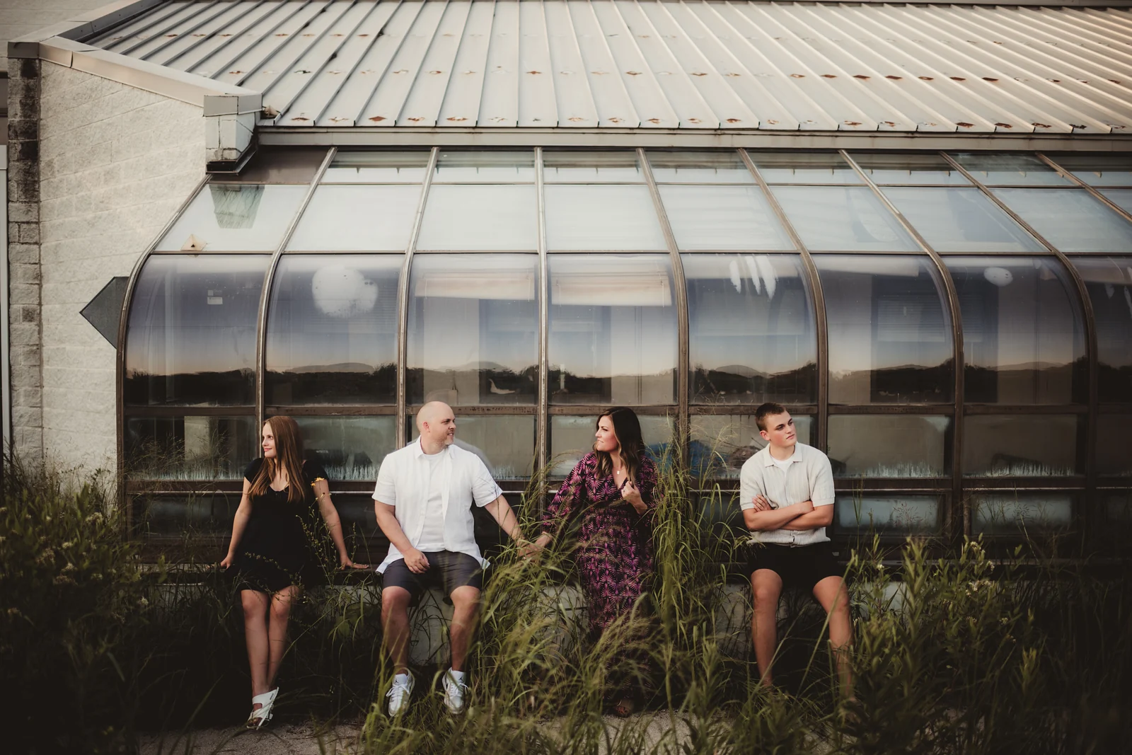 Family at a greenhouse A family holding hands in front of a glass greenhouse.