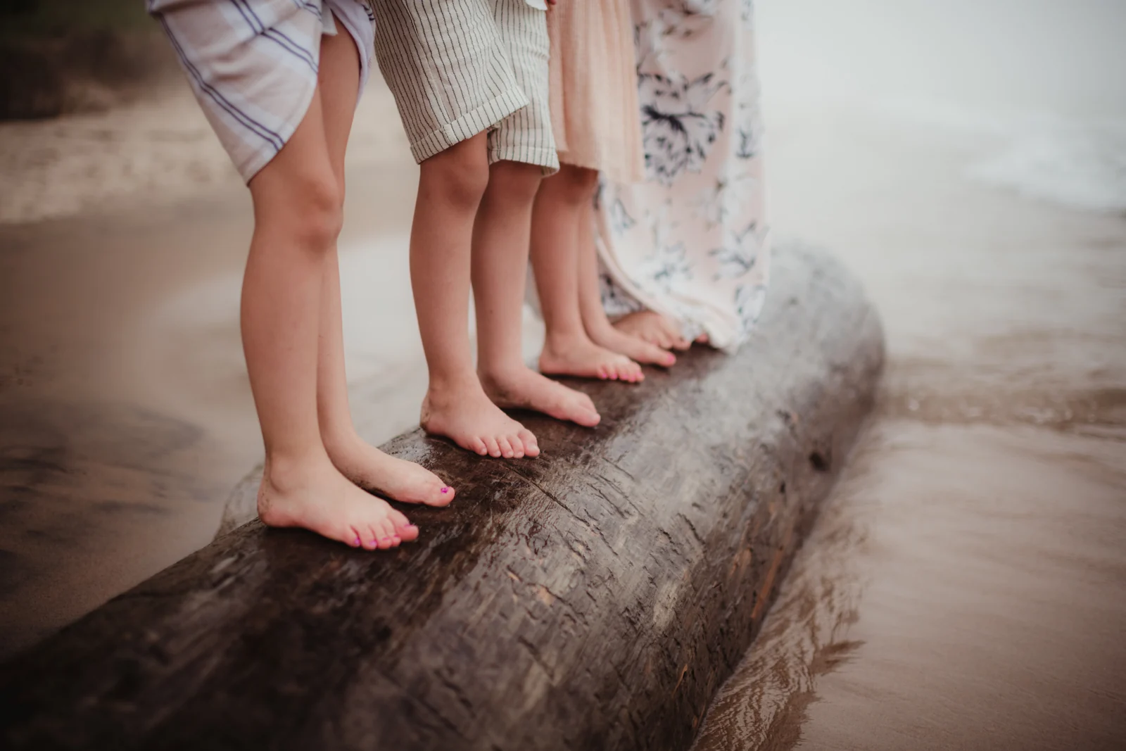 Family bare feet by the water A close view of bare feet lined up along a stone edge beside the water.