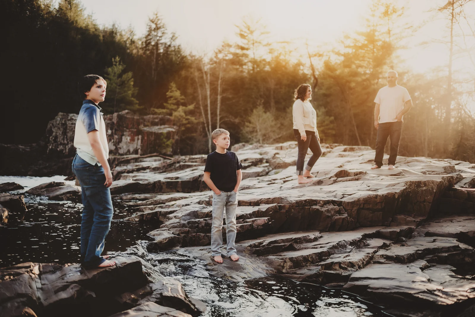 Family exploring shoreline rocks A family exploring broad shoreline rocks together in evening light.
