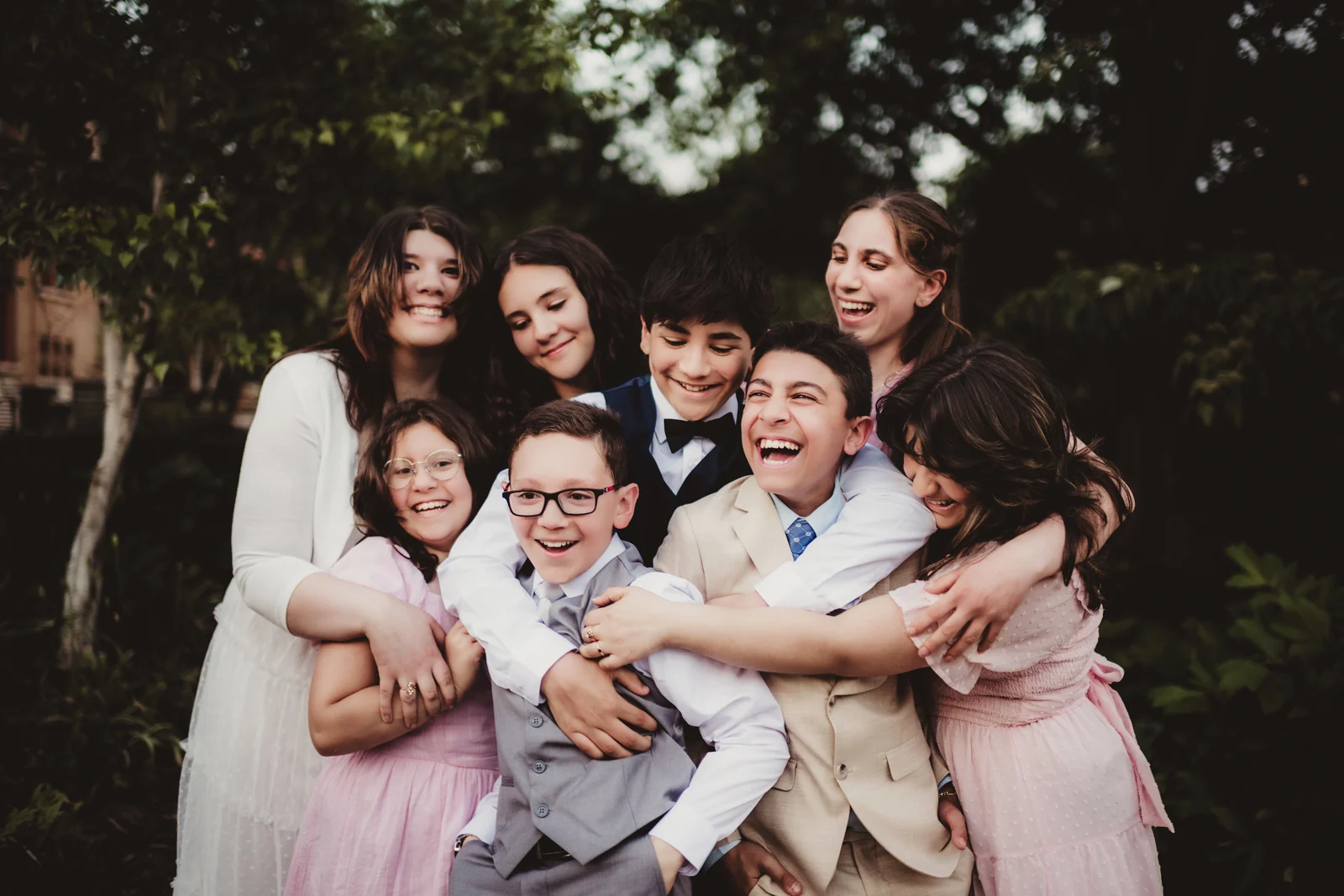 Family in a playful group hug A family laughing and squeezing together in a playful group hug.