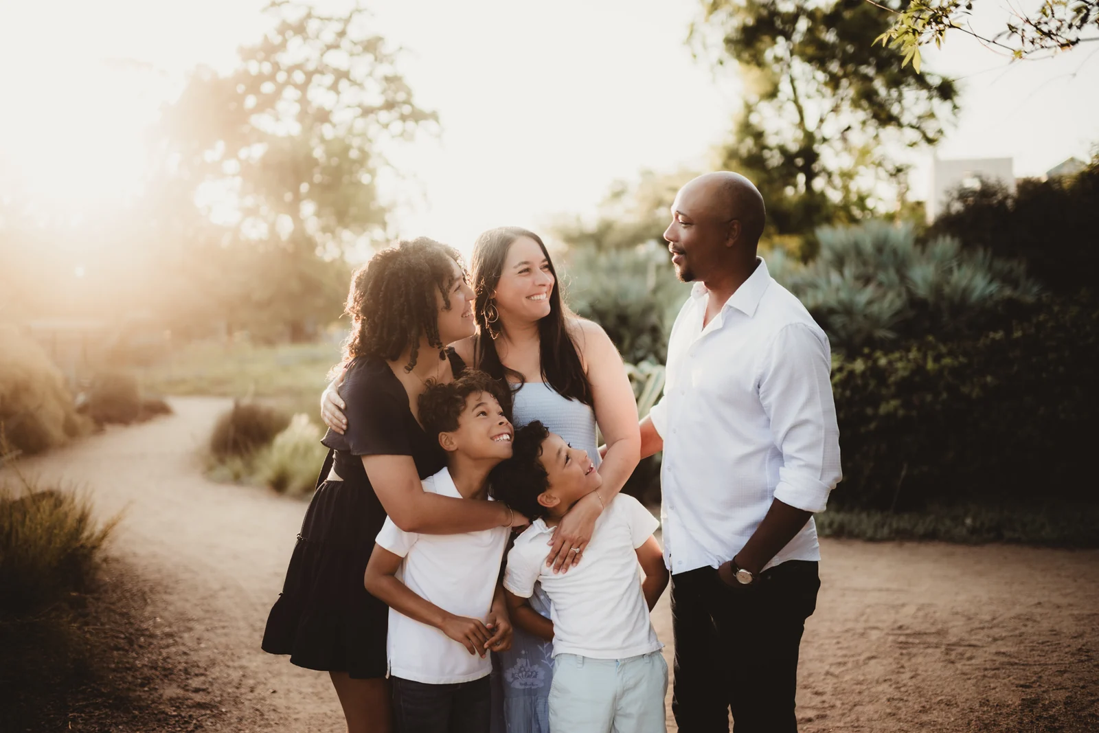 Family laughing together A family leaning together and laughing in warm evening light.