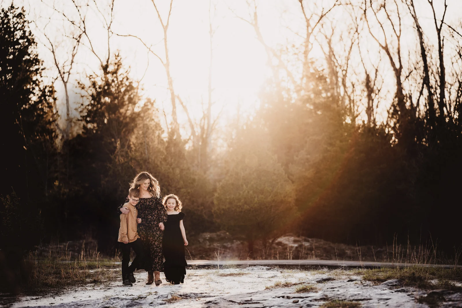 Family walking through winter light A family walking together through snow in warm winter light.