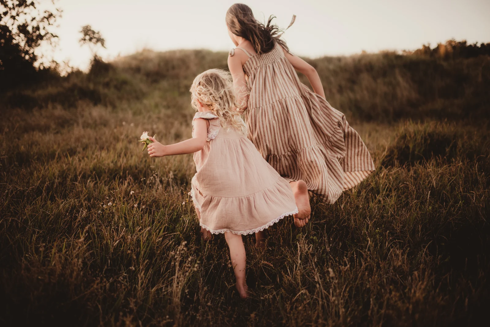Parent and child dancing A parent and child twirling together through a grassy field.
