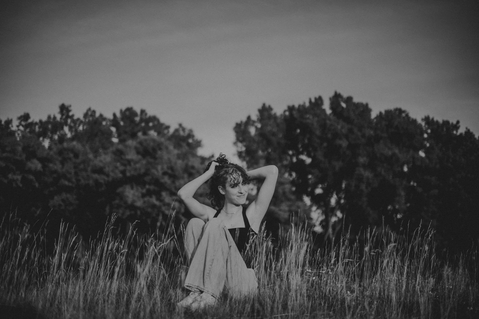 to-senior-2026-senior-black-and-white-meadow A black and white portrait of a senior posing in an open meadow.