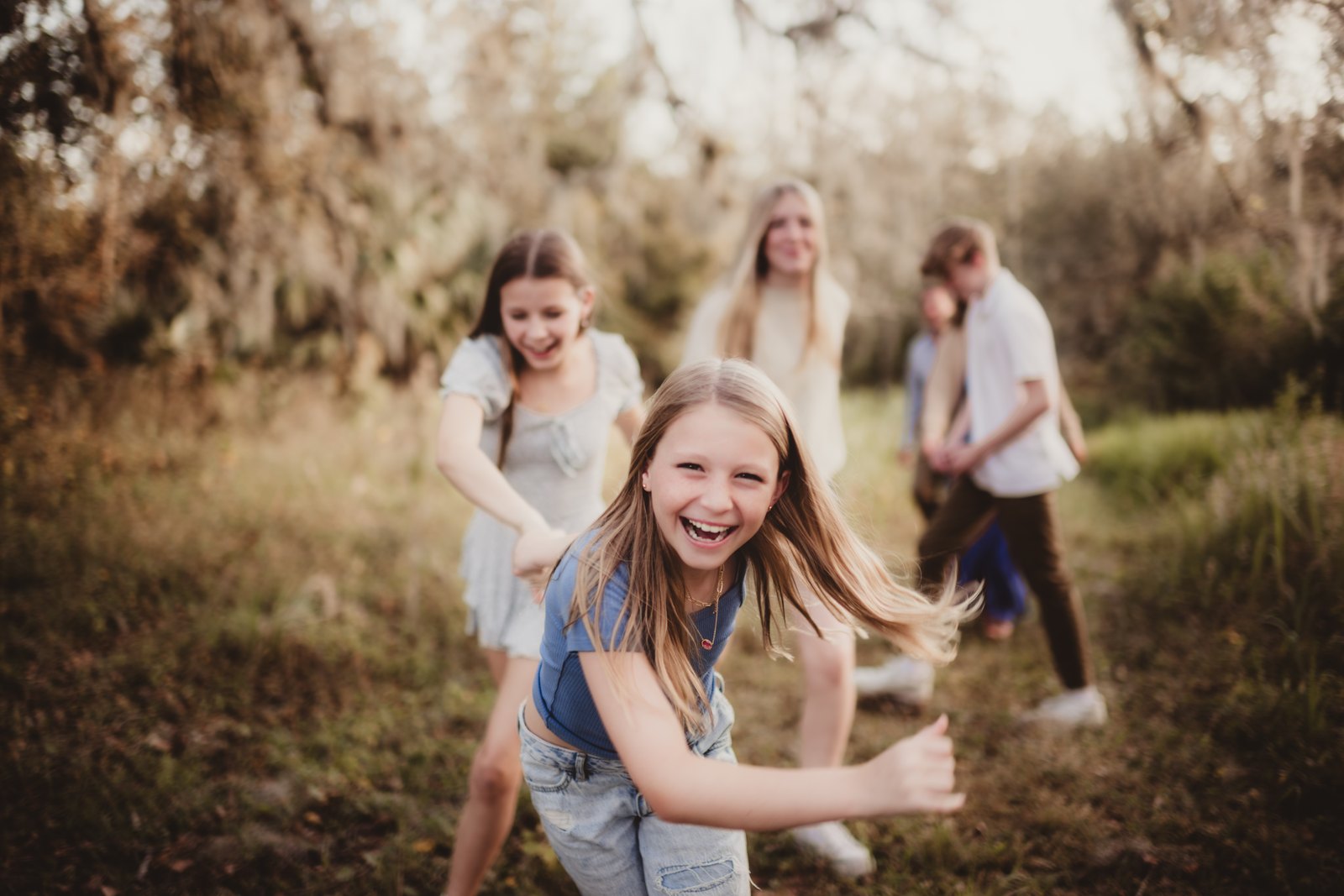 Laughing child running toward the camera with her family at Bonnet Springs Park.