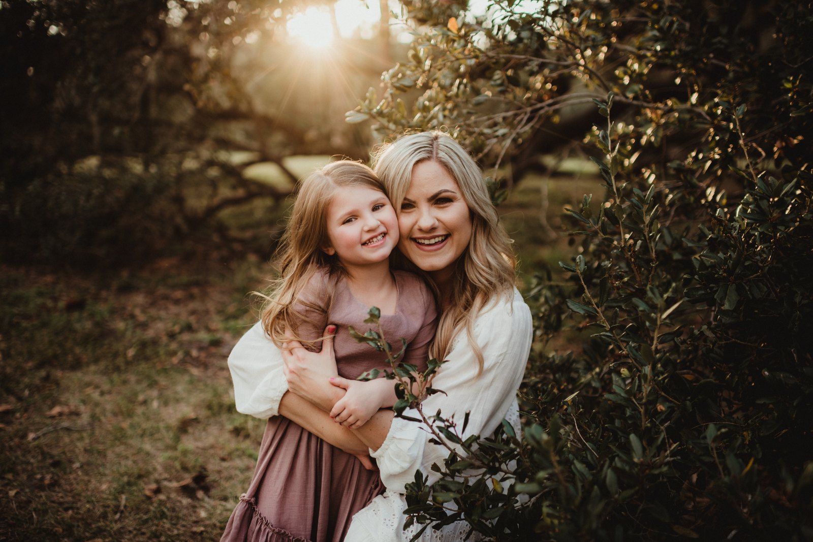 Mother and daughter hugging in warm evening light at Philippe Park.